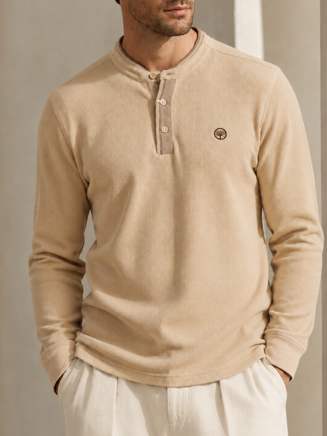 Cambuzo premium para hombre color beige con cuello tipo henley, manga larga, logo bordado y ajuste cómodo para uso casual.