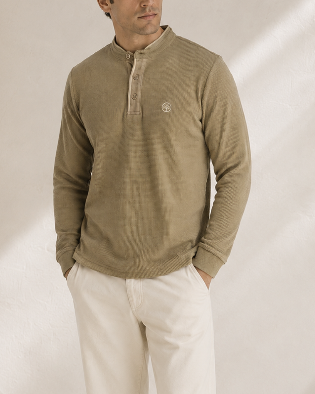 Cambuzo premium para hombre color beige con cuello tipo henley, manga larga, logo bordado y ajuste cómodo para uso casual.