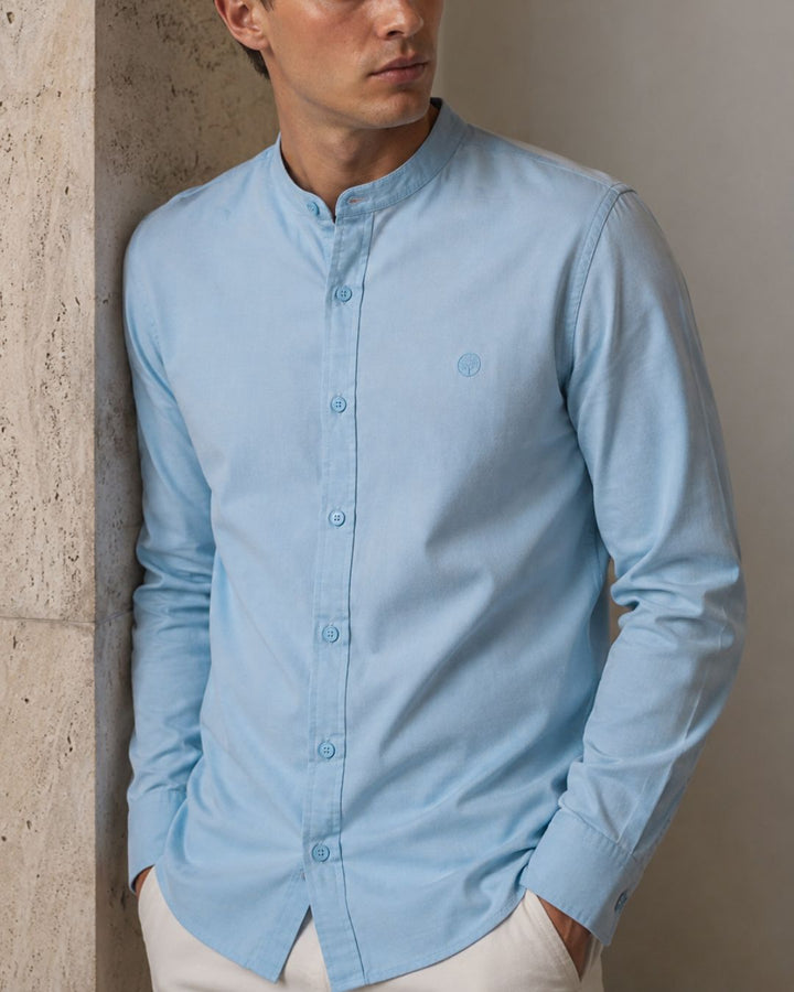 Una camisa pensada para sentirse tan bien como se ve. Su tejido en algodón de la India con acabado micropunto ofrece una sensación suave, fresca y cómoda sobre la piel, ideal para usar durante todo el día sin perder estructura ni elegancia.

Su composición de 66% algodón, 30% poliéster reciclado y 2% licra combina frescura, suavidad y flexibilidad. La presencia de poliéster ayuda a que la prenda se arrugue menos y sea mucho más fácil de planchar, mientras que la licra aporta libertad de movimiento y mayor c