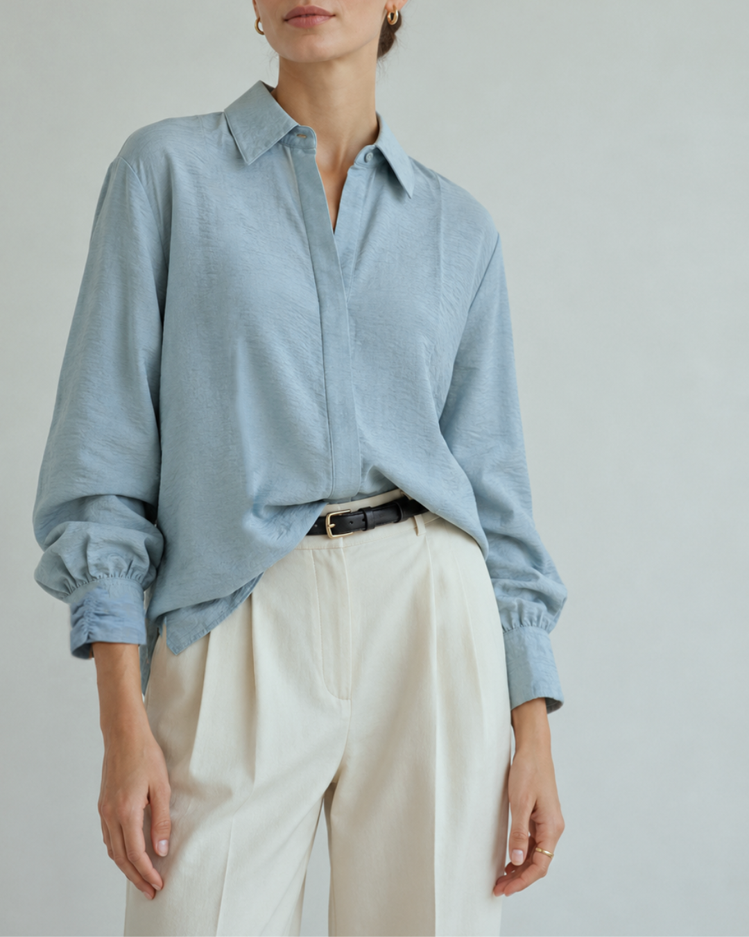 – Camisa de horma amplia
– Tela ligera, fluida y texturizada
– Composición: 85% viscosa, 15% nylon
– Cuello camisero clásico
– Botones ocultos con tapeta frontal
– Puños con diseño recogido
– Manga larga con volumen sutil
– Espalda con pieza superior y pliegue central
– Largo cómodo con caída natural
– Ideal para looks elegantes, casuales o de oficina