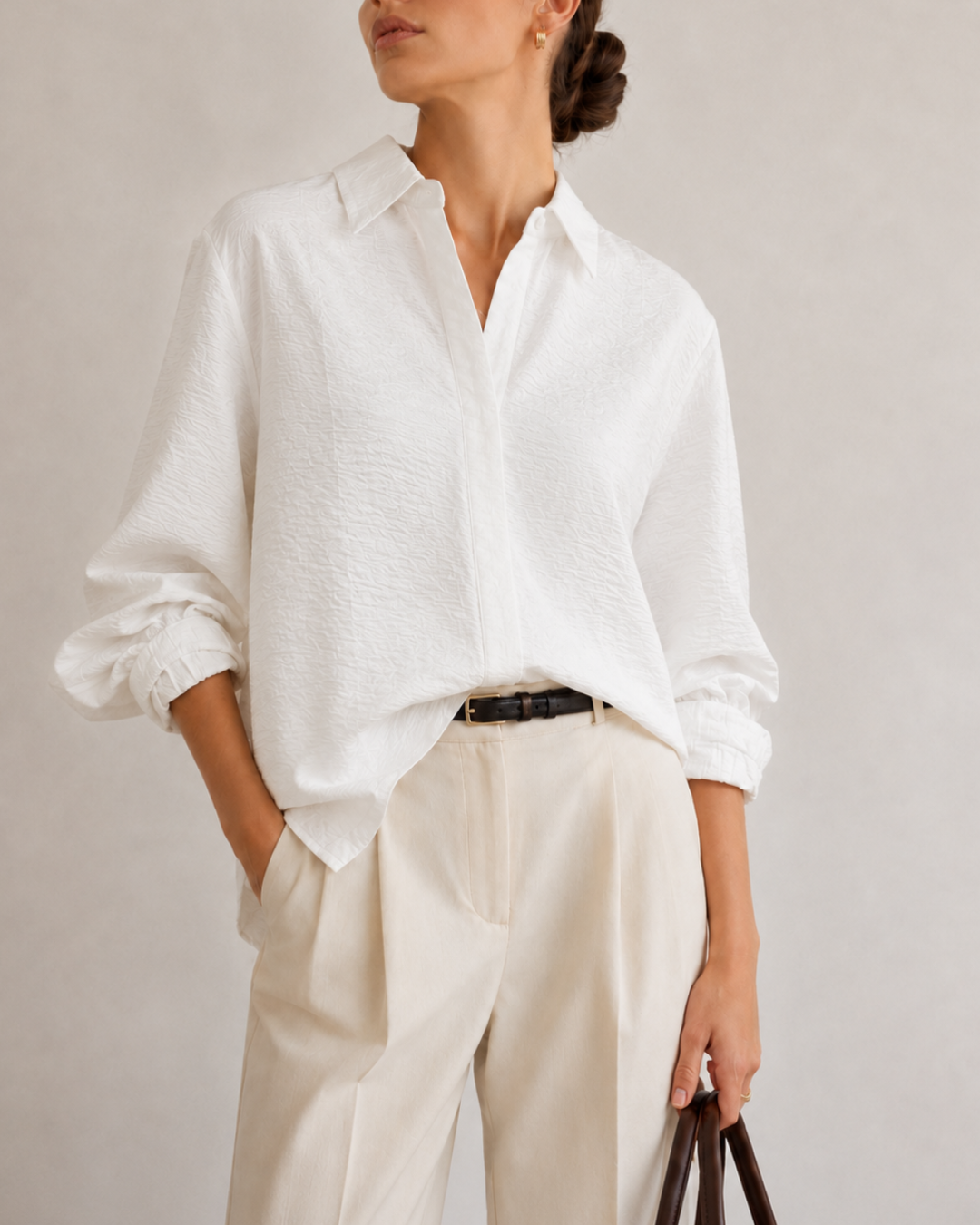 – Camisa de horma amplia
– Tela ligera, fluida y texturizada
– Composición: 85% viscosa, 15% nylon
– Cuello camisero clásico
– Botones ocultos con tapeta frontal
– Puños con diseño recogido
– Manga larga con volumen sutil
– Espalda con pieza superior y pliegue central
– Largo cómodo con caída natural
– Ideal para looks elegantes, casuales o de oficina