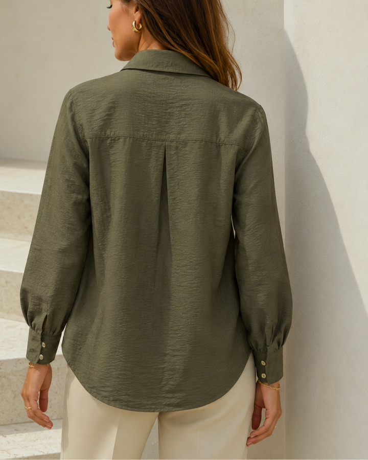 – Camisa de horma amplia
– Tela ligera, fluida y texturizada
– Composición: 85% viscosa, 15% nylon
– Cuello camisero clásico
– Botones ocultos con tapeta frontal
– Puños con diseño recogido
– Manga larga con volumen sutil
– Espalda con pieza superior y pliegue central
– Largo cómodo con caída natural
– Ideal para looks elegantes, casuales o de oficina