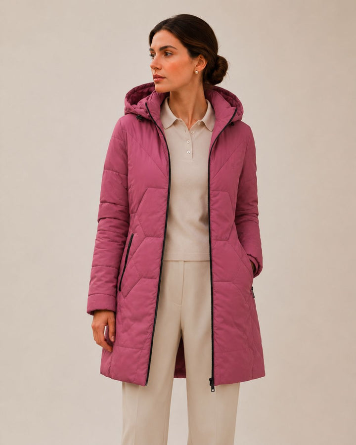 "Chaqueta larga acolchada bicolor verde y fucsia para mujer vista frontal con capucha."

