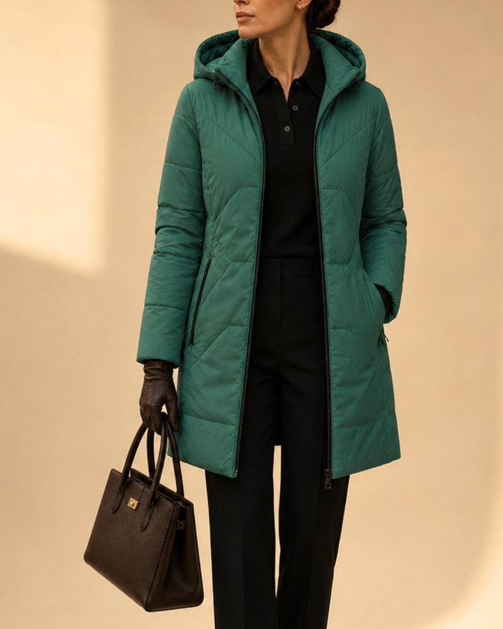 "Chaqueta larga acolchada bicolor verde y fucsia para mujer vista frontal con capucha."
