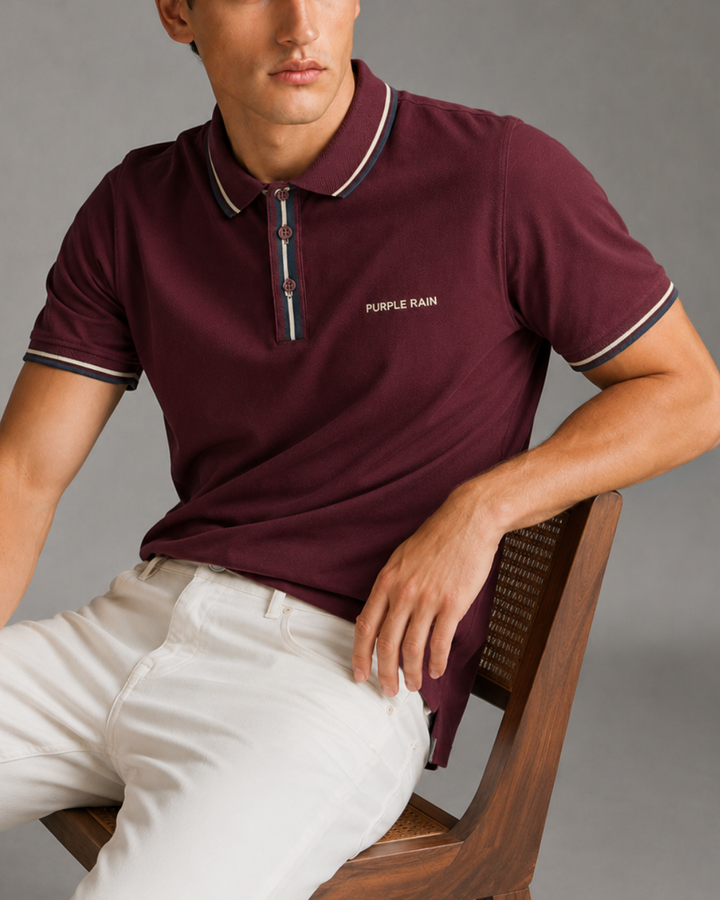 Polo Riviera Melange para hombre color gris jaspeado con cuello tejido azul marino y café, tapeta con contraste y logo bordado Purple Rain.