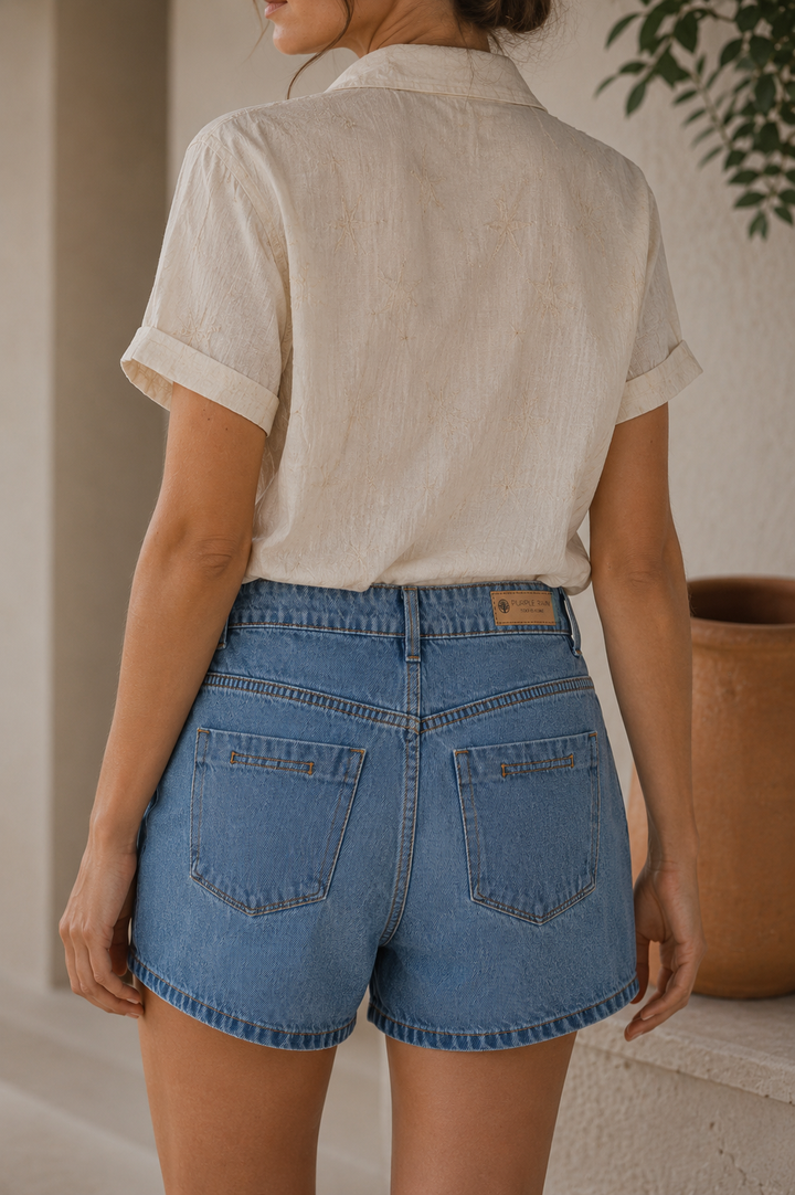 Short denim para mujer
Color azul claro
Tiro alto
Botonadura frontal metálica visible
Diseño de cuatro botones
Silueta cómoda y favorecedora
Bolsillos delanteros funcionales
Bolsillos posteriores funcionales
Pasadores para cinturón
Lavado claro con efecto envejecido sutil
Acabado premium
Fácil de combinar