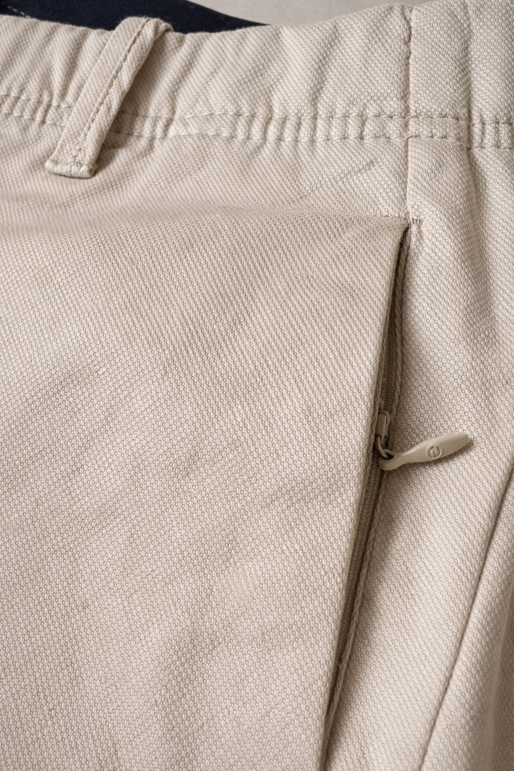 "Pantalón masculino color caramelo en drill texturizado tipo micropunto, vista posterior en primer plano. Diseño slim fit con bolsillos traseros ribeteados, botón decorativo, cremallera lateral discreta y marquilla Purple Rain en la pretina. Acabados premium y textura refinada visible en la tela."