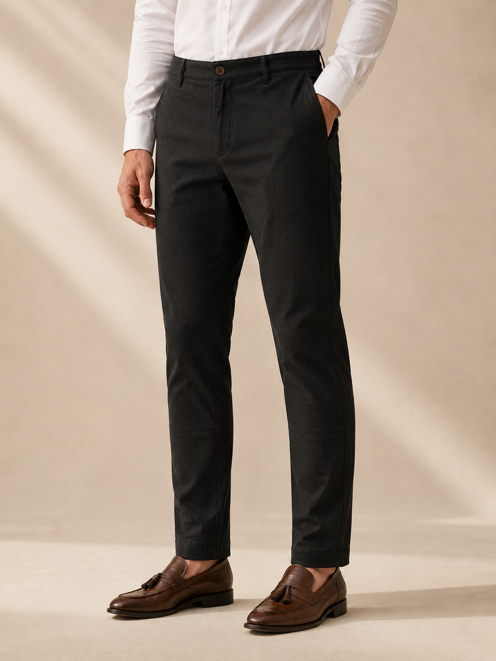 "Pantalón masculino color caramelo en drill texturizado tipo micropunto, vista posterior en primer plano. Diseño slim fit con bolsillos traseros ribeteados, botón decorativo, cremallera lateral discreta y marquilla Purple Rain en la pretina. Acabados premium y textura refinada visible en la tela."