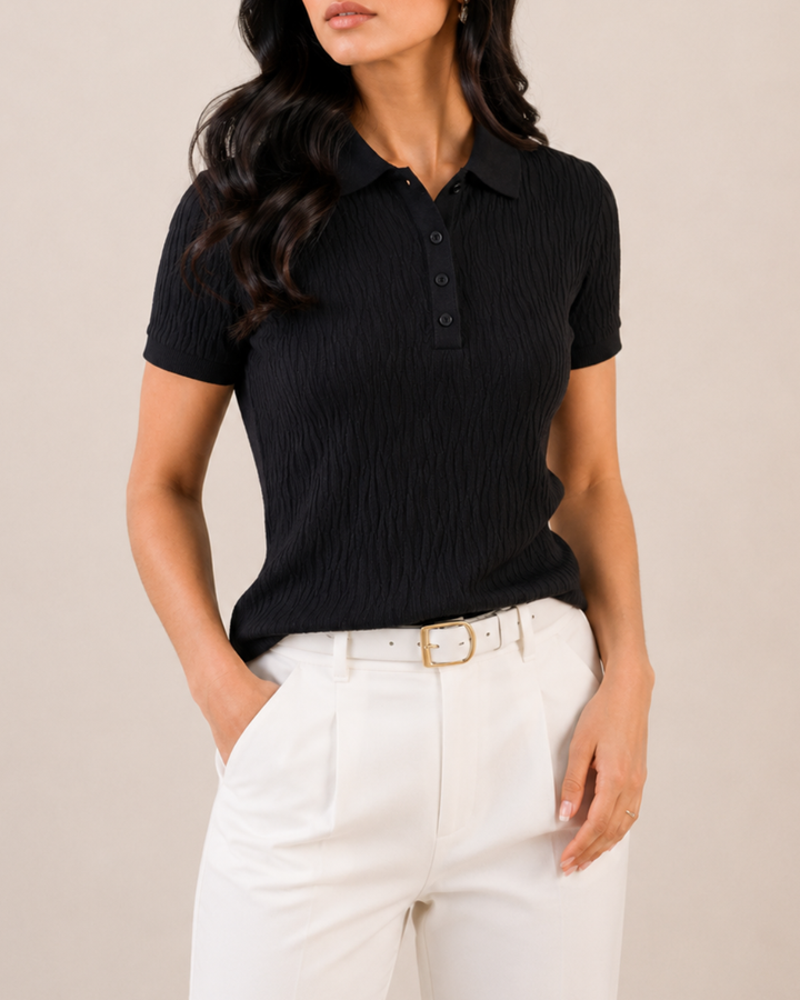 Polo tejido negro para mujer con cuello clásico y manga corta. Diseño atemporal perfecto para looks formales y casuales.
