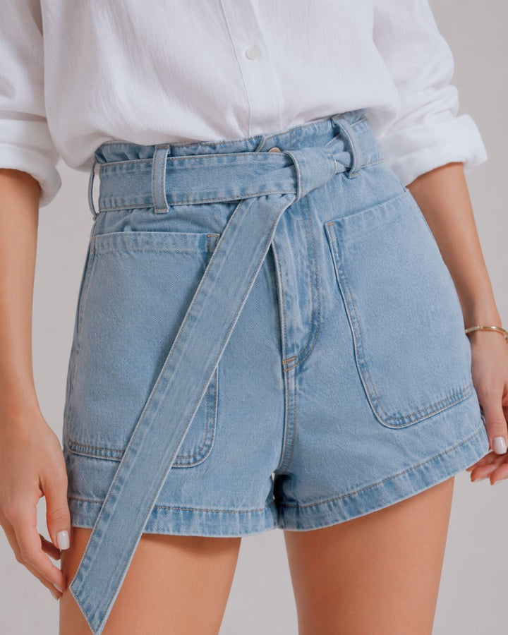 Short denim azul claro para mujer con tiro alto y cinturón elaborado en la misma tela. Diseño femenino que estiliza la silueta y aporta comodidad para el día a día. bolsillos de parche 